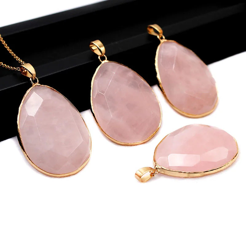 Pink teardrop pendants with gold frames on a white background