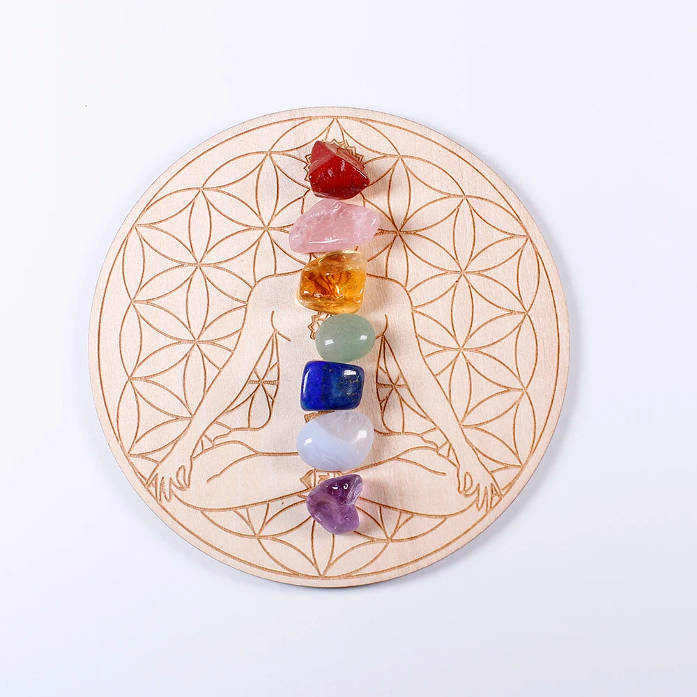 Chakra stones on a wooden plate with a geometric design