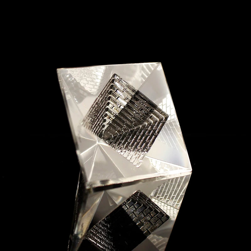Crystal pyramid with geometric patterns on a black background