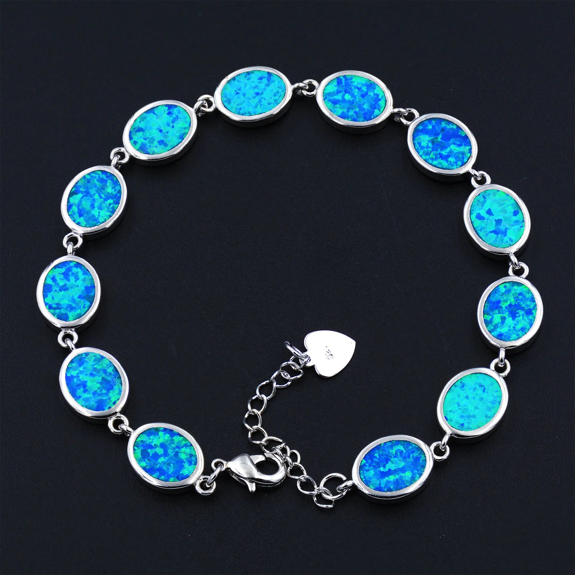 Silver bracelet with blue opal stones on a black background