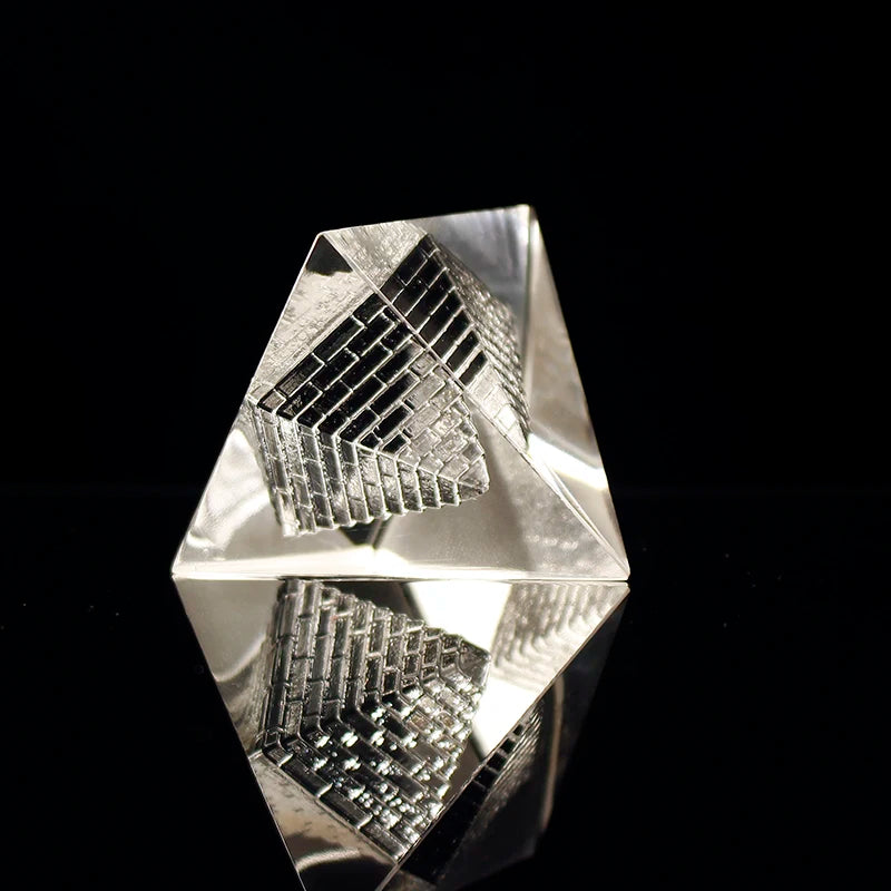 Silver geometric pyramid with intricate design on a black background