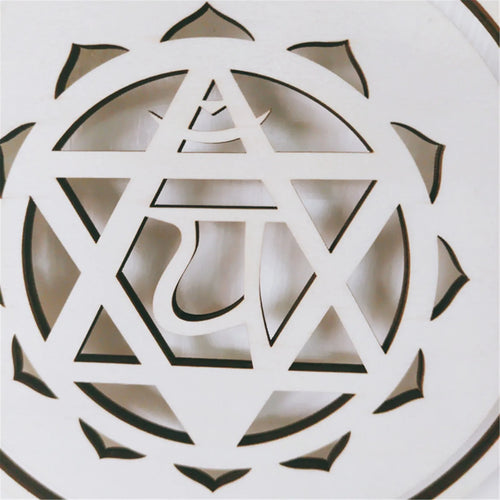 Decorative white object with geometric cut-out design on a light background