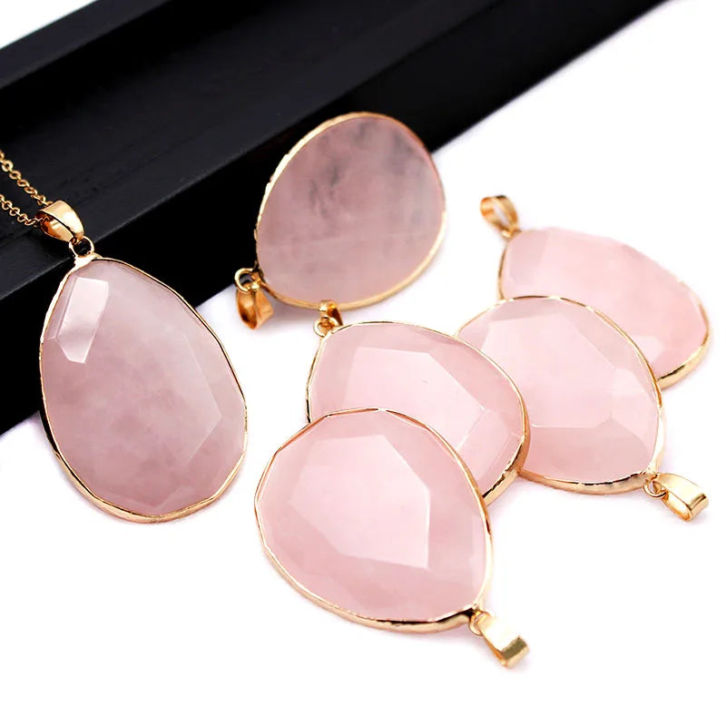 Pink stone pendants with gold accents on a white surface