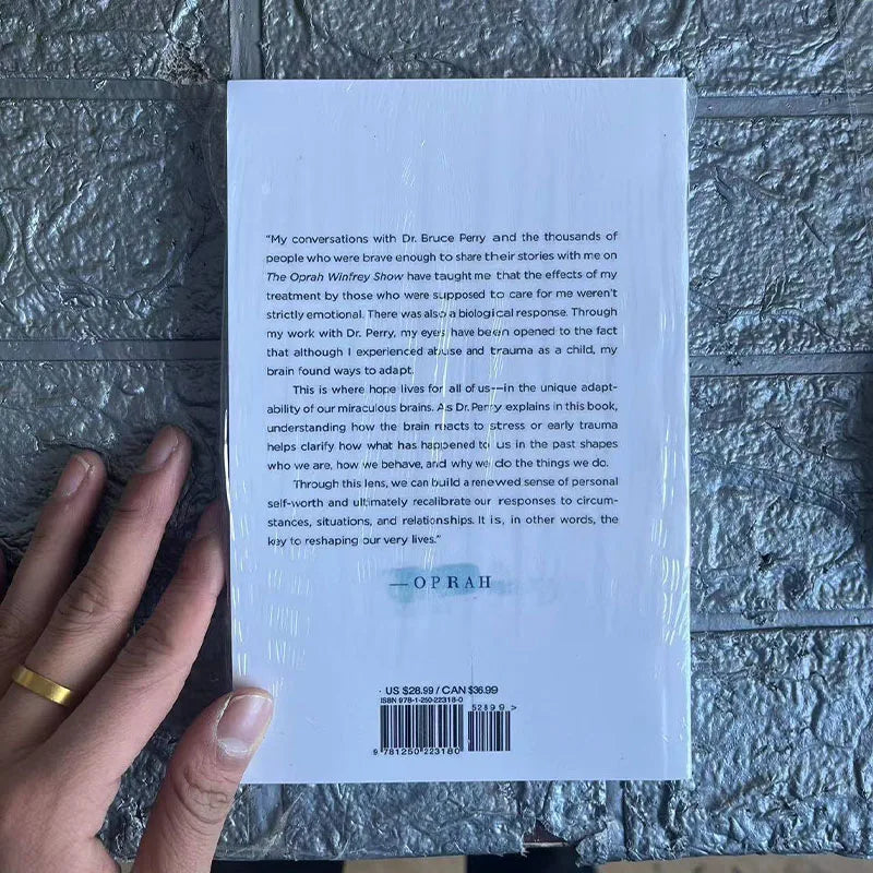 Book back cover held by a hand on a textured surface