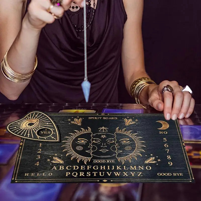 Person with hands on a spirit board with astrological symbols and letters.