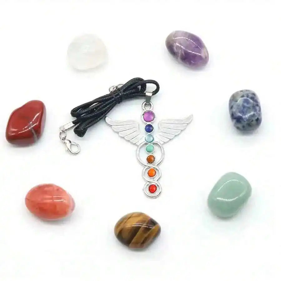 Pendant with chakra stones surrounded by various crystals on a white background