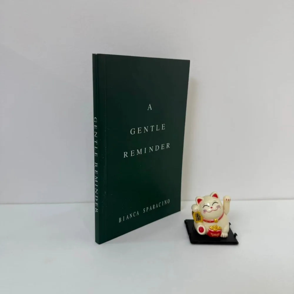 Book titled 'A Gentle Reminder' by Bianca Sparacino with a small figurine on a white background
