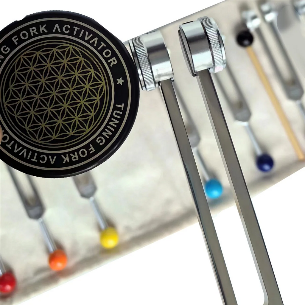 Tuning fork activator with colorful tuning forks on a white background