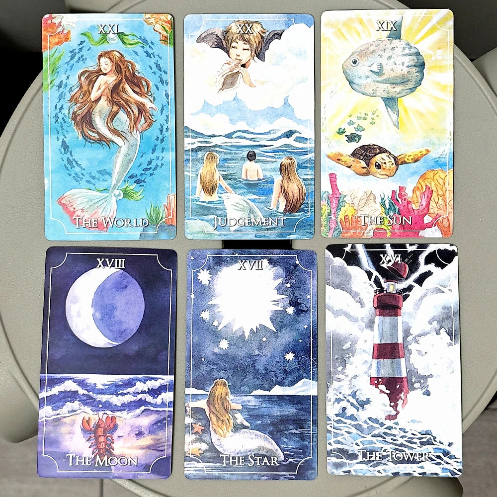 Set of tarot cards with various illustrations and text on a flat surface.