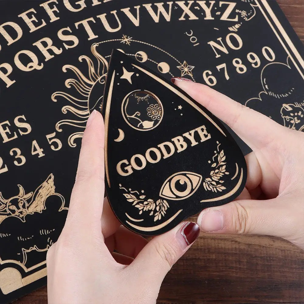 Hand holding a black and gold 'GOODBYE' card with an Ouija board in the background