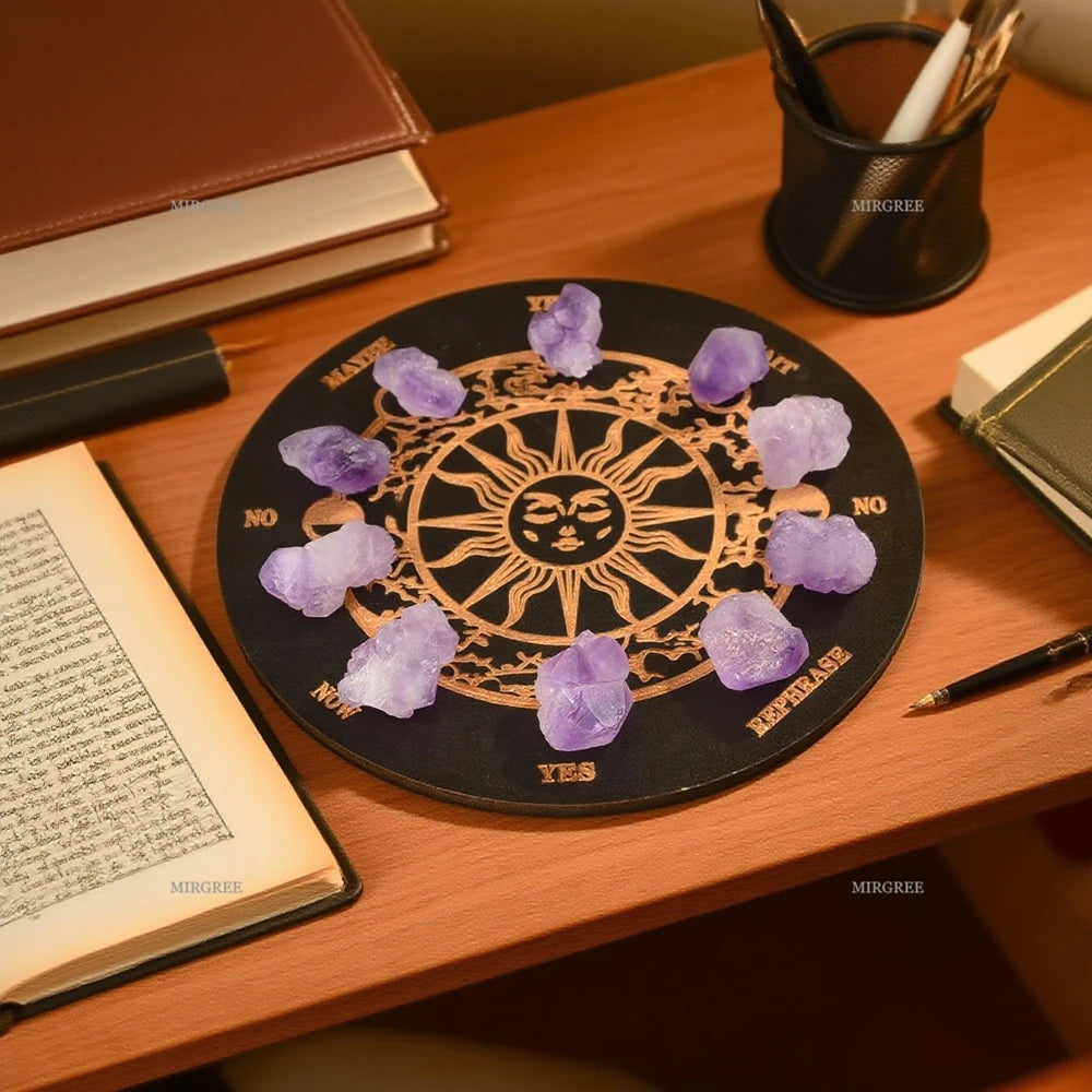 Black circular board with a sun design and purple crystals on a wooden desk.