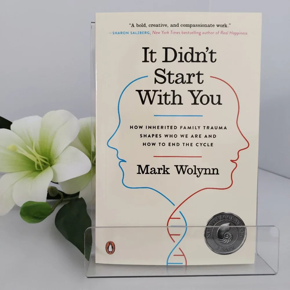 Book titled 'It Didn't Start With You' by Mark Wolynn with a flower in the background