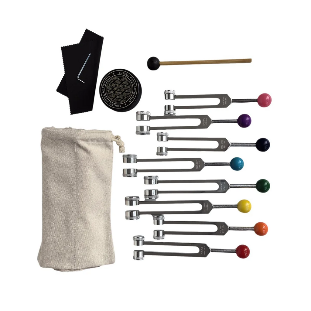 Set of tuning forks with colored ends and accessories on a white background