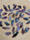 Purple and gray crystal stones on a textured beige surface