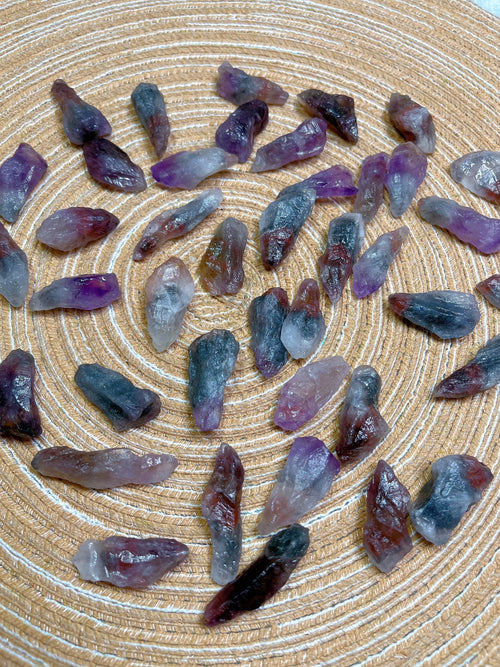 Purple and gray crystal stones on a textured beige surface