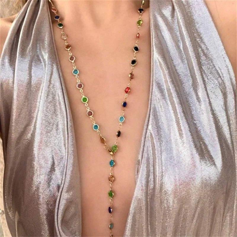 Multicolored beaded necklace on a person wearing a silver top.