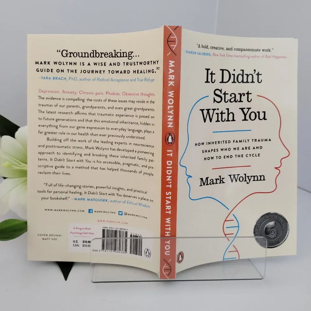 Book titled 'It Didn't Start With You' by Mark Wolynn on a stand with a white background