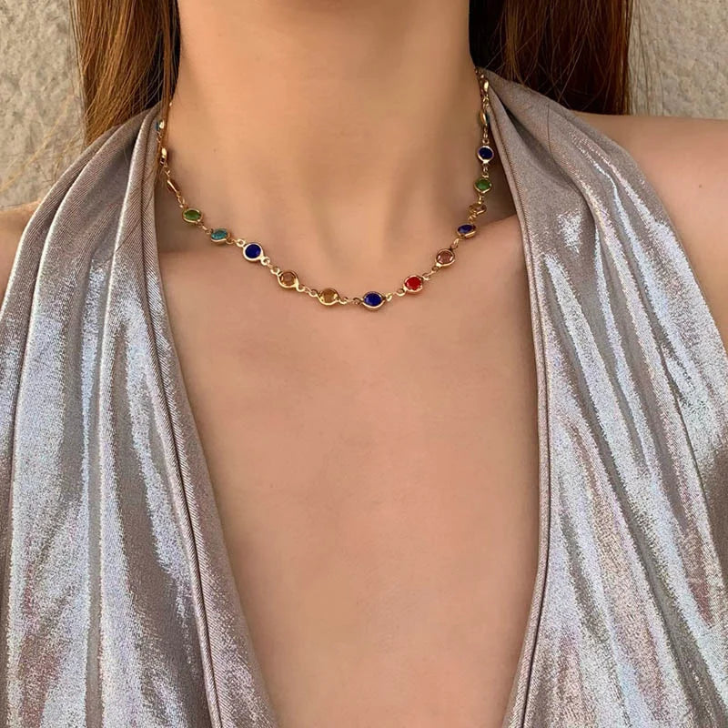 Necklace with colorful beads worn by a model in a silver dress.