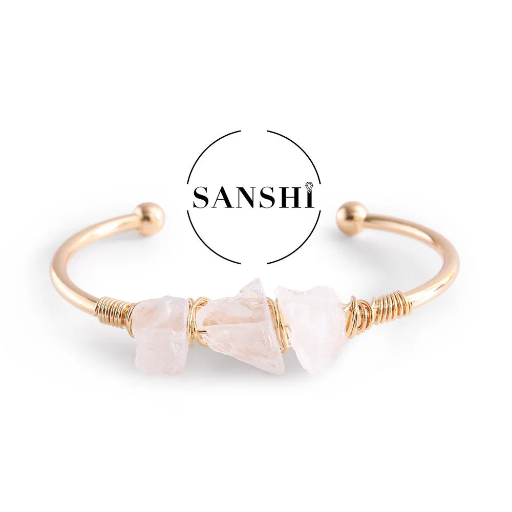 Gold bracelet with pink stones on a white background, featuring the brand 'Sanshi'.