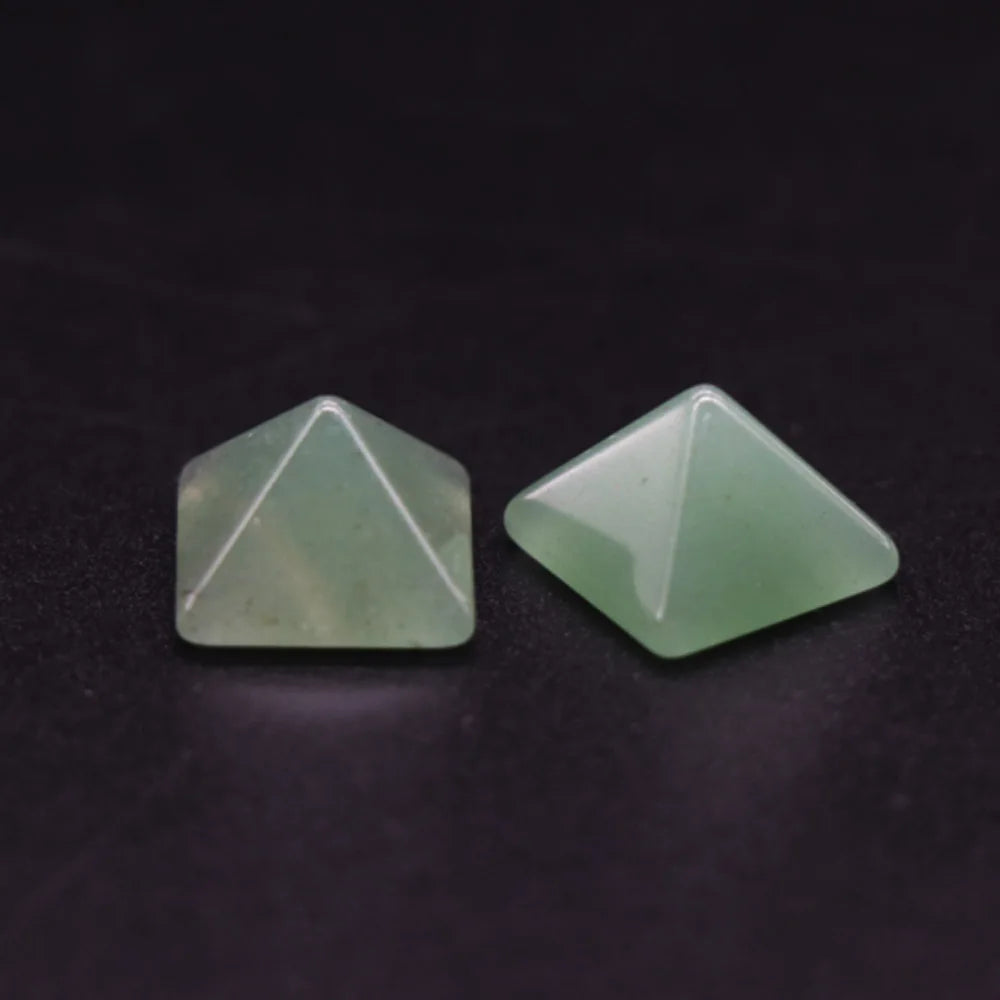 Two green geometric stones on a dark background