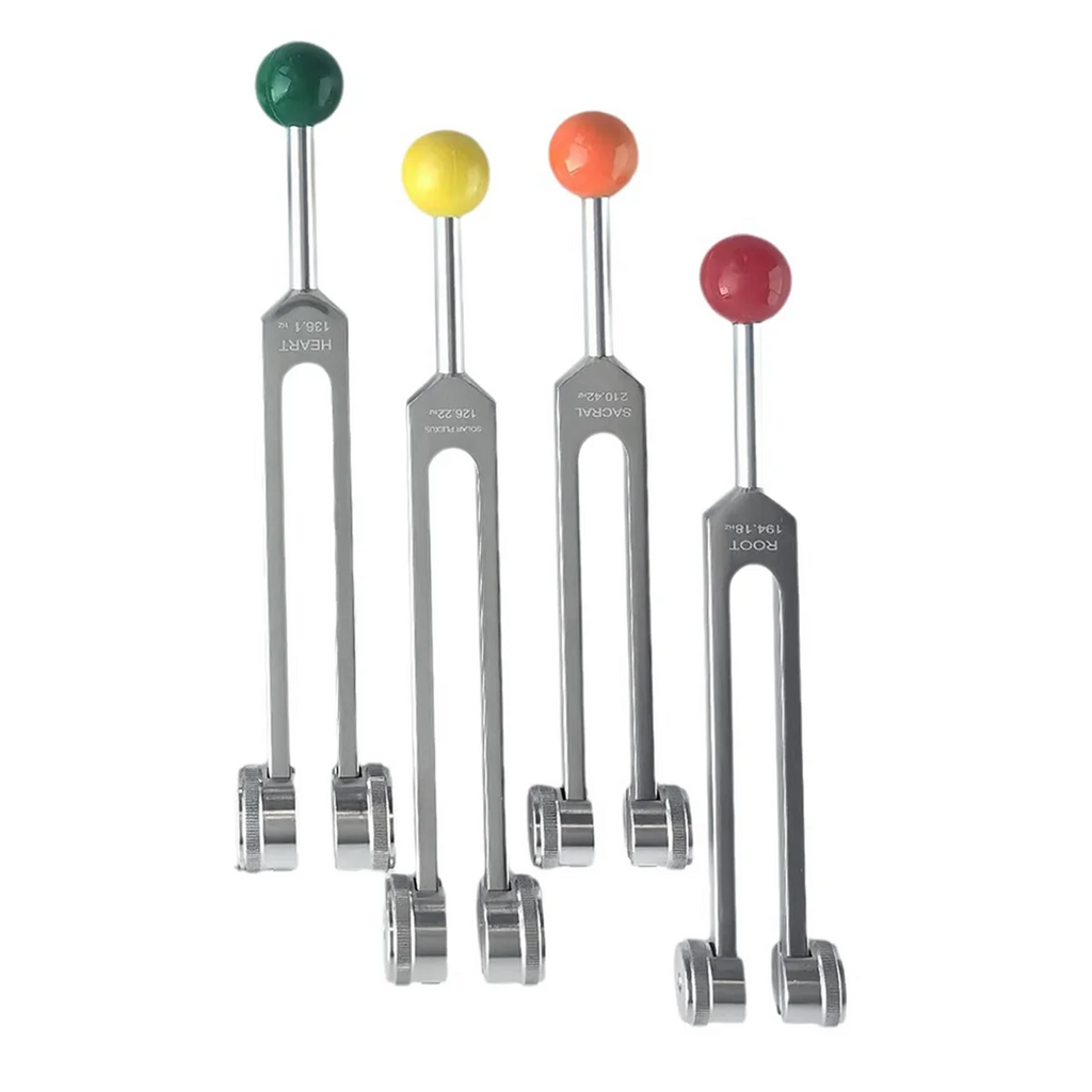 Set of four tuning forks with colored ends on a white background