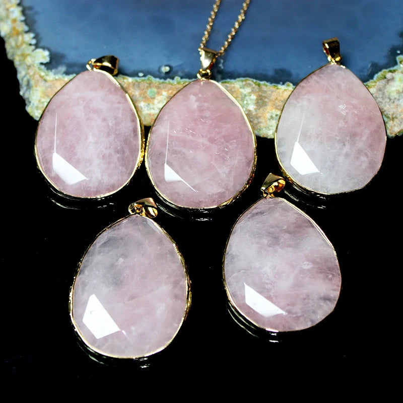 Set of pink teardrop-shaped gemstones with gold accents on a dark background