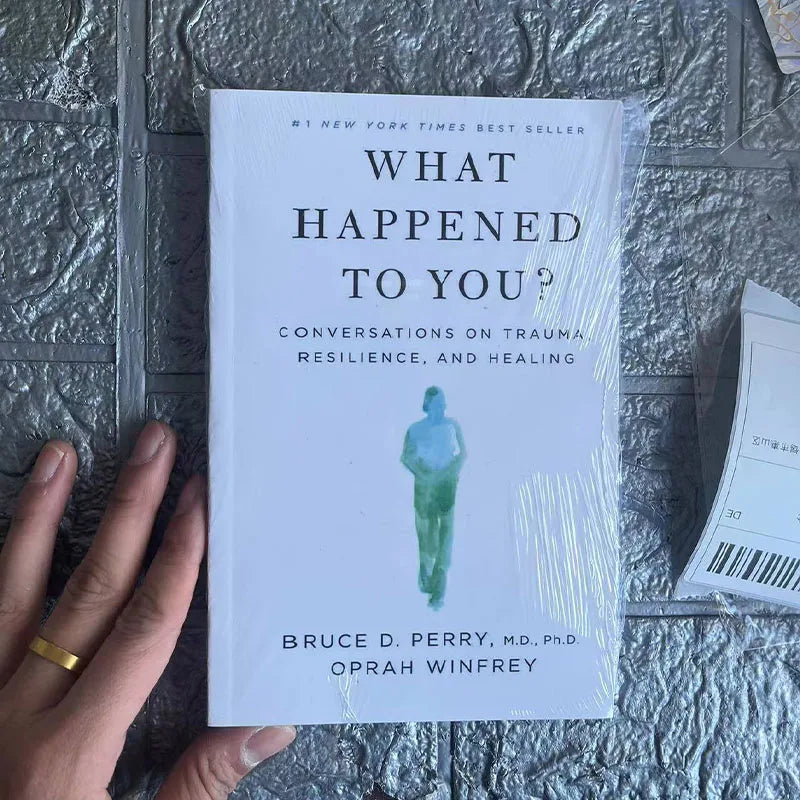 Book titled 'What Happened to You?' by Bruce D. Perry and Oprah Winfrey on a textured surface.