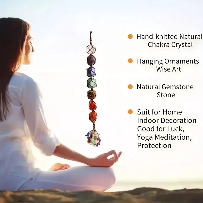 Person meditating with a hand-knitted natural chakra crystal hanging ornament in the foreground.