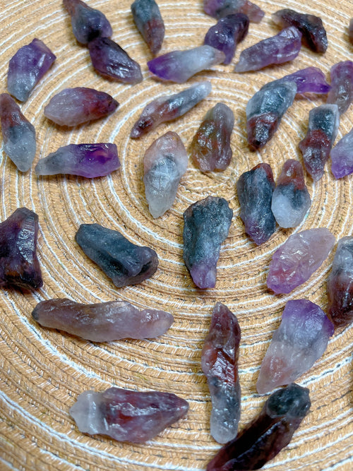 Collection of purple and gray crystals on a wooden surface