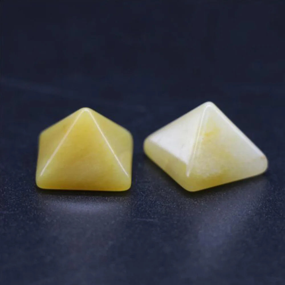 Two yellow pyramid-shaped stones on a dark surface