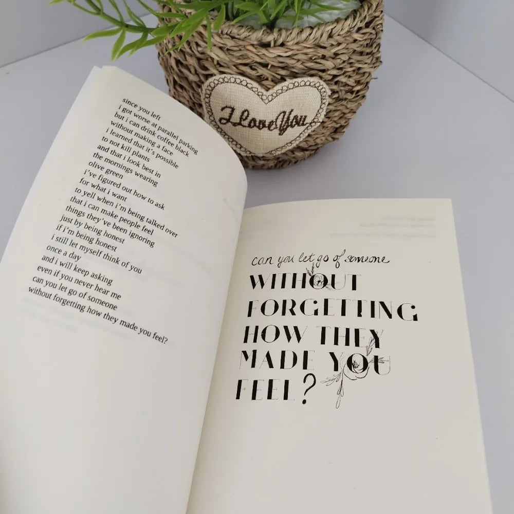 Open book with text and a heart-shaped decorative item on a white surface